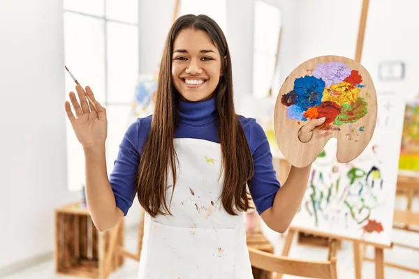 Young Latin Woman Smiling Confident Holding Paintbrush Palette Art Studio — ストック写真