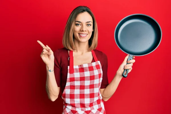 요리사 앞치마를 행복하게 손가락으로 가리키고 금발의 — 스톡 사진