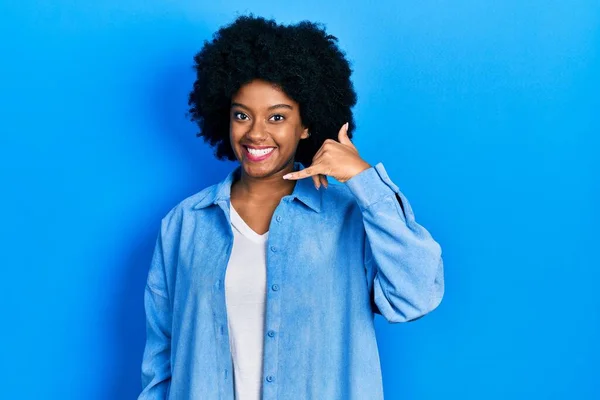 若いアフリカ系アメリカ人女性は 携帯電話で話すような手や指で携帯電話のジェスチャーをして笑顔でカジュアルな服を着ています コミュニケーションの概念 — ストック写真
