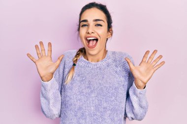 Genç İspanyol kız gündelik giysiler giyip çılgınlığı kutluyor ve başarıya hayret ediyor kolları açık ve gözleri açık heyecanla haykırıyor. Kazanan konsept 