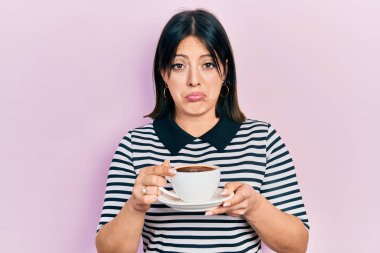 Genç İspanyol kadın bir fincan kahve içiyor. Depresyonda ve üzüntüden ağlıyor. Kızgın ve korkmuş. hüzünlü ifade. 