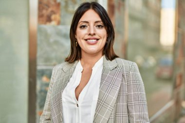 Genç İspanyol iş kadını şehirde mutlu mesut ayakta duruyor..