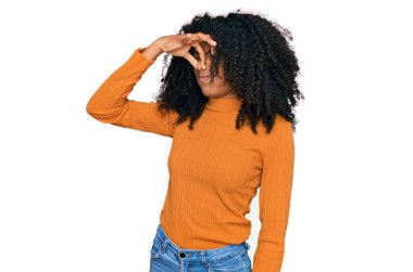 Genç Afro-Amerikan kızı günlük kıyafetler giyip pis ve iğrenç bir koku alıyor. Nefesini burnunda tutuyor. Kötü kokuyor. 