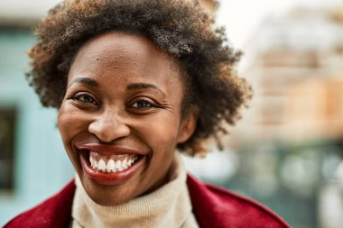 Güzel bir iş adamı Afro saçlı Amerikalı kadın şehirde mutlu ve kendinden emin bir şekilde gülümsüyor.