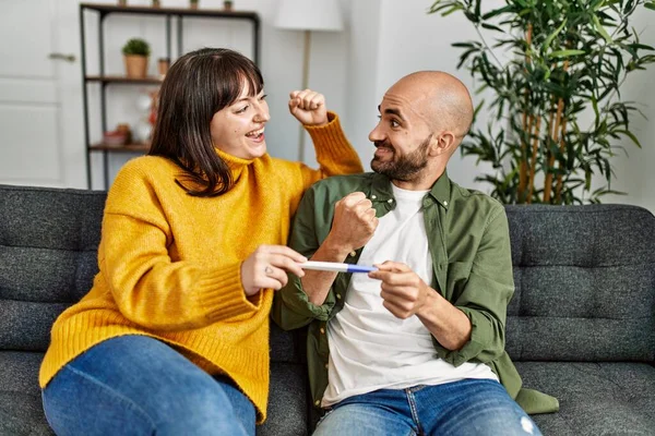 Unga Latinamerikanska Par Ler Glad Innehav Graviditetstest Sitter Soffan Vid — Stockfoto