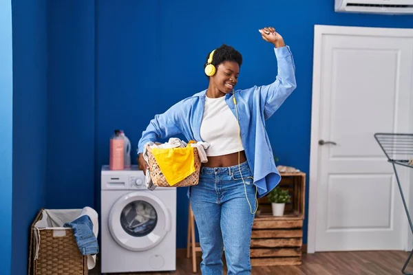 African American Woman Holding Basket Clothes Listening Music Laundry Room — ストック写真