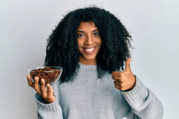 Afro Amerikaanse Vrouw Met Afro Haar Houden Rozijnen Kom Glimlachen — Stockfoto