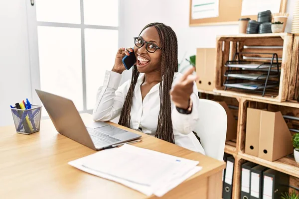 Black Woman Braids Working Office Speaking Phone Pointing Fingers Camera — Fotografia de Stock