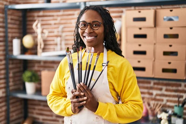 African American Woman Artist Smiling Confident Holding Paintbrushes Art Studio — ストック写真