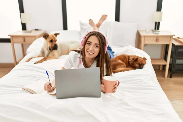 Young Hispanic Woman Studying Lying Bed Dogs Bedroom — ストック写真