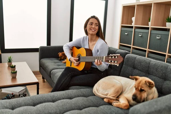 Jovem Hispânica Tocando Guitarra Clássica Sentada Sofá Com Cães Casa — Fotografia de Stock