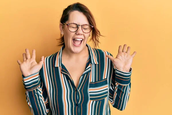 Gündelik kıyafetler giyen ve gözlük takan genç beyaz kadın başarı için çılgınca ve çılgınca kutlama yaparken kollarını kaldırmış ve gözlerini kapatmış heyecanlı çığlıklar atıyordu. Kazanan konsept 