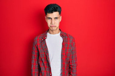 Günlük giysiler giyen genç İspanyol bir adam depresyonda ve sıkıntıdan endişe ediyor, kızgın ve korkmuş bir şekilde ağlıyor. hüzünlü ifade. 