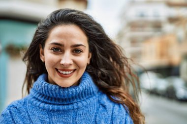 Genç İspanyol kadın gülümseyerek şehirde mutlu mesut dikiliyor..