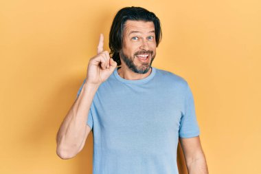 Sıradan kıyafetler giyen orta yaşlı beyaz bir adam başarılı bir fikri işaret ediyor. Heyecanlı ve mutlu. Bir numara.. 