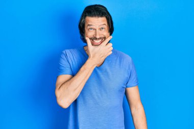 Orta yaşlı, günlük kıyafetler giyen, kameraya kendinden emin kollarını kavuşturup gülümseyen ve çenesini kaldıran beyaz bir adam. Olumlu düşünmek. 