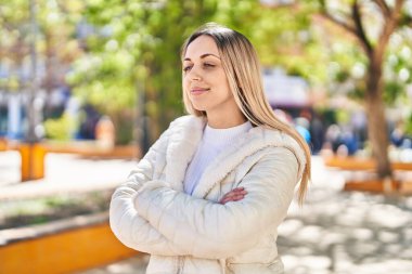 Young woman smiling confident standing with arms crossed gesture at park