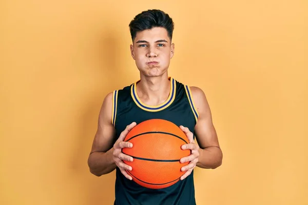 Молодой Латиноамериканец Держит Баскетбольный Мяч Пушистыми Щеками Смешным Лицом Рот — стоковое фото
