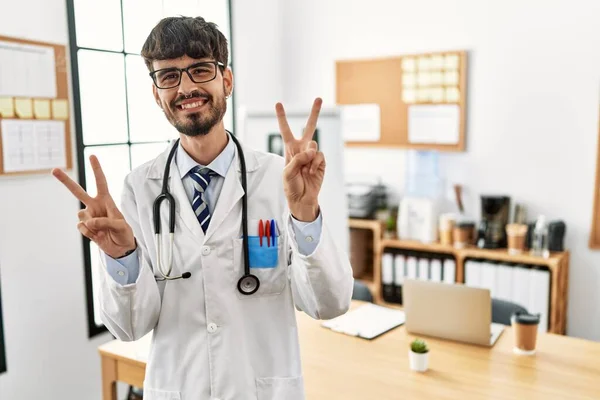 Sakallı Doktor Üniforması Giyen Steteskop Takmış Kameraya Bakıp Zafer Işareti — Stok fotoğraf