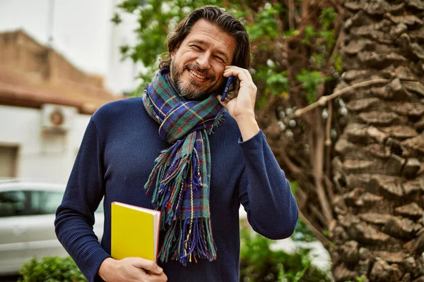 Orta yaşlı yakışıklı adam parkta dışarıda telefonla konuşuyor.