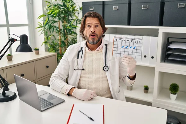 Handsome Middle Age Doctor Man Holding Holidays Calendar Scared Amazed — Stock Photo, Image