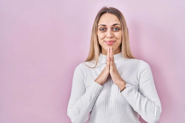 Giovane Donna Bionda Che Indossa Maglione Bianco Sfondo Rosa Pregando — Foto Stock