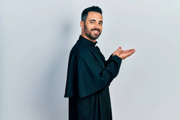 Handsome Hispanic Man Beard Wearing Catholic Priest Robe Pointing Aside — Stock Fotó