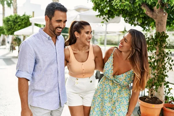 Üç İspanyol arkadaş şehirde mutlu bir şekilde gülüyor ve sarılıyorlar..