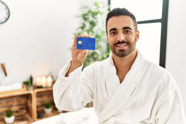 Young Hispanic Man Wearing Bathrobe Holding Credit Card Beauty Center — Foto Stock