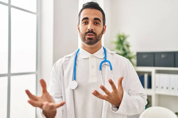 Young Hispanic Man Wearing Doctor Uniform Speaking Clinic — Stockfoto