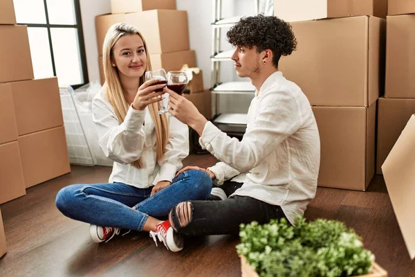 Genç ve güzel bir çift gülümsüyor. Yeni evlerinde kırmızı şarapla kadeh kaldırıyorlar.