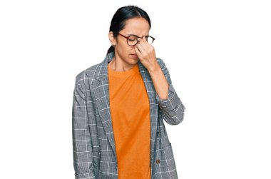 İş ceketi ve gözlük takan genç İspanyol kız yorgun burnu ve gözleri ovuşturup yorgunluk ve baş ağrısı çekiyor. Stres ve hüsran kavramı. 