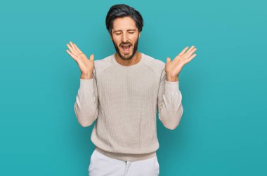 Gündelik kıyafetler giyen genç İspanyol adam başarı için deli ve çılgınlığı kutluyor kollarını kaldırmış ve gözlerini kapatmış heyecanla bağırıyor. Kazanan konsept 