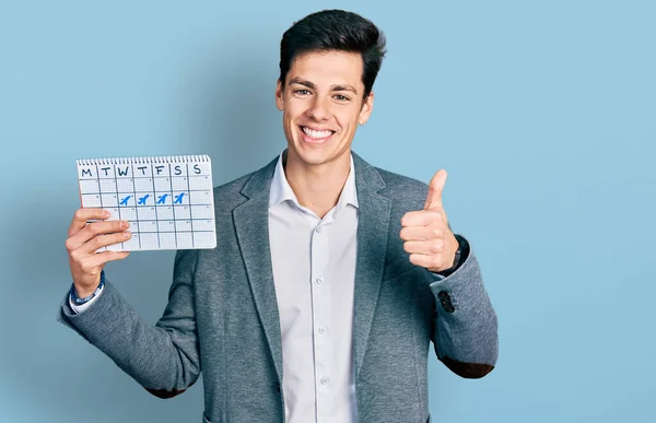 Νεαρός Ισπανόφωνος Επιχειρηματίας Κρατώντας Ημερολόγιο Ταξιδιού Χαμογελώντας Χαρούμενος Και Θετικός — Φωτογραφία Αρχείου