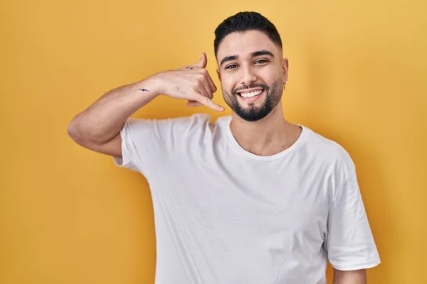Mladý Pohledný Muž Neformální Tričku Přes Žluté Pozadí Usmívající Mávající — Stock fotografie