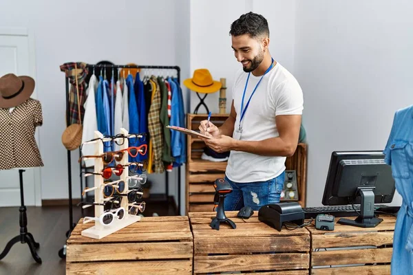 Genç Arap esnaf mağazasında çalışan bir panoya yazı yazıyor.