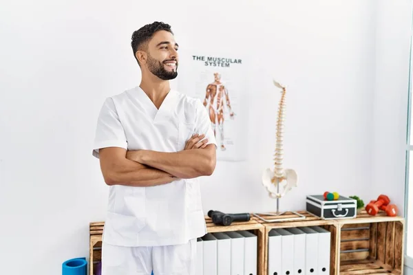 Junger Arabischer Mann Physiotherapeutenuniform Steht Mit Verschränkten Armen Klinik — Stockfoto
