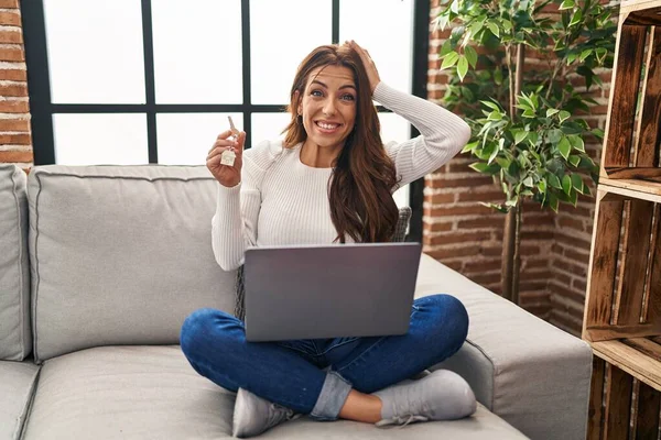 Young Brunette Woman Using Laptop Holding Keys New Home Stressed — Stockfoto