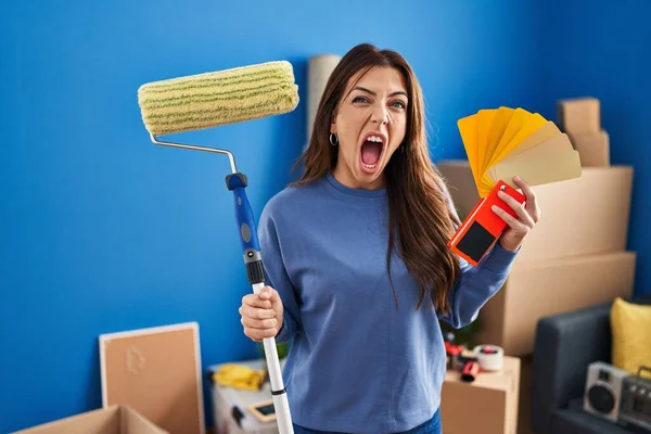 Young Brunette Woman Holding Roller Painter Painting New House Angry — Stok fotoğraf