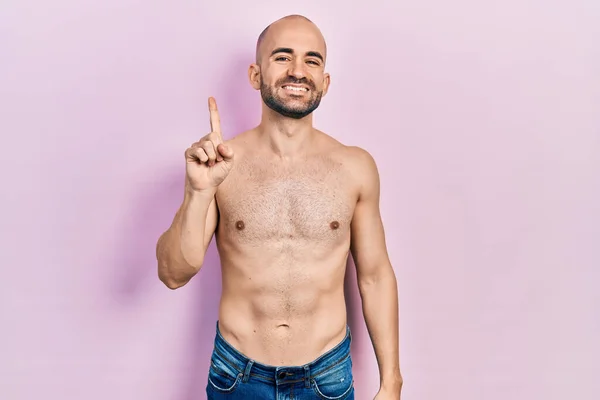 Jovem Careca Sem Camisa Mostrando Apontando Para Cima Com Dedo — Fotografia de Stock