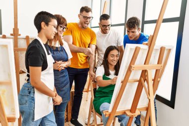 Mutlu gülümseyen ve ortak arayan bir grup insan sanat stüdyosunda..