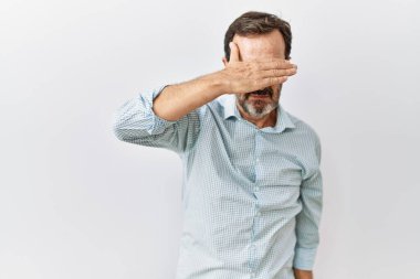 Orta yaşlı, sakallı, soyutlanmış arka planda duran, gözlerini kapayan, ciddi ve üzgün görünen İspanyol bir adam. Görme, saklama ve reddetme konsepti 