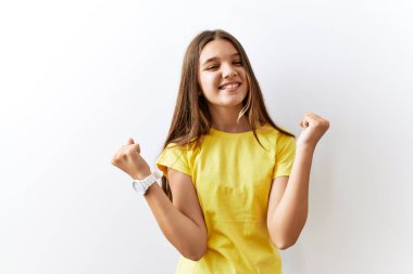 Genç esmer kız, izole edilmiş arka planda bir arada durup kolları havada ve gözleri kapalı bir şekilde başarının şaşkınlığını ve şaşkınlığını kutluyor. Kazanan konsept. 