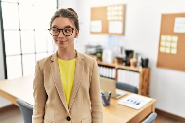 Genç esmer genç, iş yerinde iş elbisesi giymiş gülümseyip yan tarafa bakıyor ve düşünüyor.. 