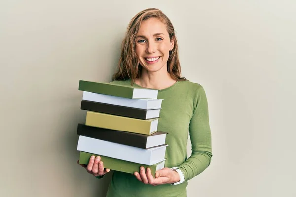 Mujer Rubia Joven Sosteniendo Montón Libros Sonriendo Con Una Sonrisa — Foto de Stock
