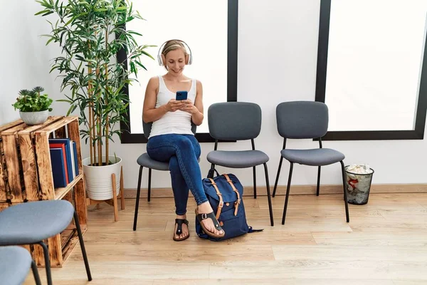 Young Caucasian Woman Using Smartphone Headphones Sitting Chair Waiting Room — Photo