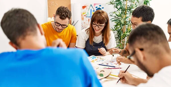 Resim stüdyosunda çizim yapan bir grup insan..