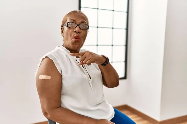 Mature Hispanic Woman Getting Vaccine Showing Arm Band Aid Surprised — ストック写真