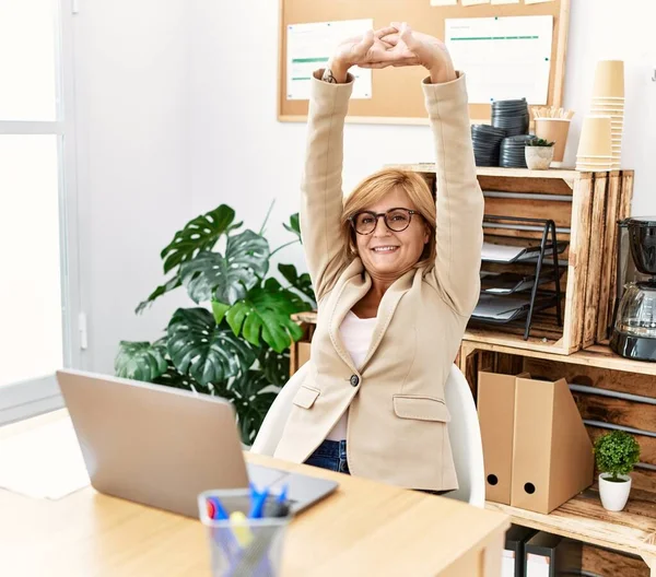 Middelbare Leeftijd Blonde Vrouw Stretching Armen Kantoor — Stockfoto