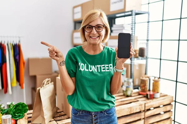 Orta Yaşlı Sarışın Kadın Gönüllü Tişört Giyiyor Akıllı Telefon Ekranını — Stok fotoğraf